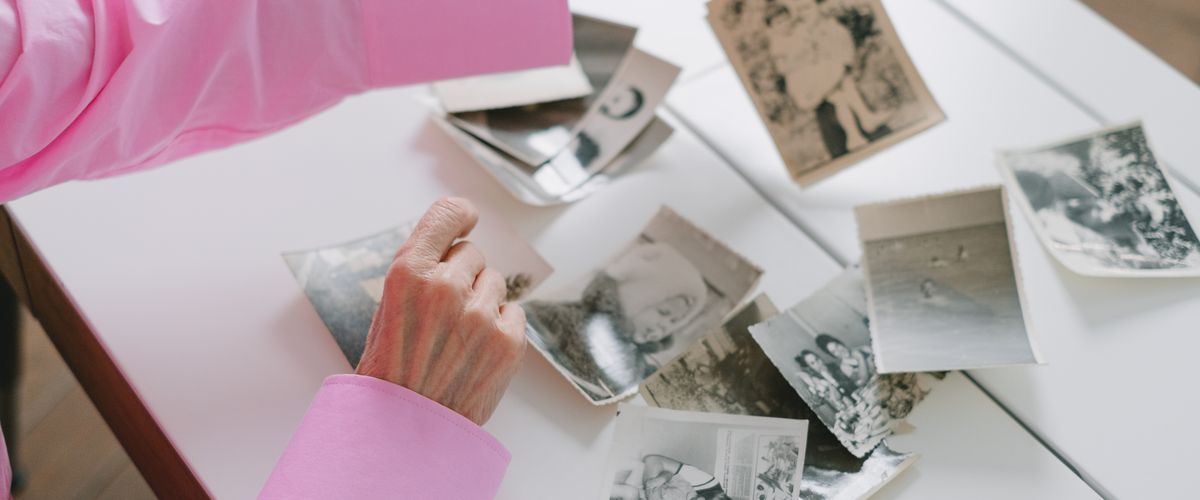 An elderly woman looking through a family photo album