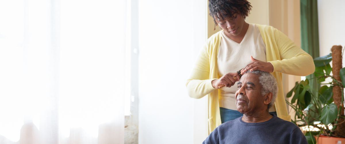 A caregiver helping an elderly person with daily grooming
