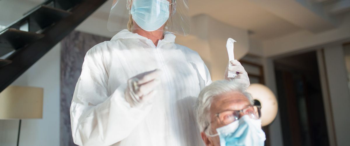 A nurse checking on an elderly patient during a home visit