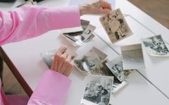 An elderly woman looking through a family photo album