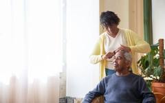 A caregiver helping an elderly person with daily grooming
