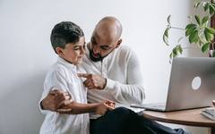An adult son talking with his elderly father at home