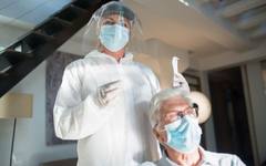 A nurse checking on an elderly patient during a home visit