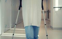 A recovering patient walking with support after a hospital stay